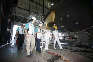 Kamarulzaman (second right) walking inside the hangar where the refit is being conducted. Note the open front end of the submarine.