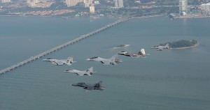 A formation of U.S. Air Force and Royal Malaysian Air Force aircraft including an F-15 Eagle from the 131st Fighter Squadron, 104th Fighter Wing, Barnes Air National Guard Base, Mass., an RMAF SU-30MKM Flanker, a USAF F-22 Raptor from the 154th Wing, Joint Base Pearl Harbor-Hickam, Hawaii, an RMAF MIG-29N Fulcrum, an BAE Hawk, and an RMAF F/A-18 Hornet fly over the Penang Bridge in Penang, Malaysia, during Cope Taufan 14, June 18, 2014. 