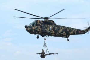 A PUTD Nuri helicopter carrying an Oto Melara 105mm pack howitzer for the firing exercise.